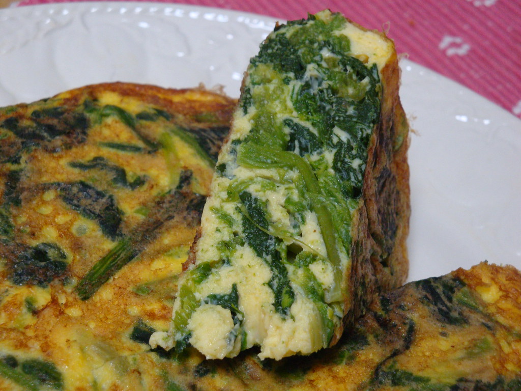 Sliced spinach omelette on a white plate