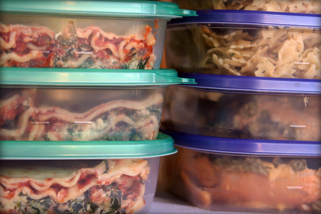 Stacked plastic containers filled with frozen leftover meals