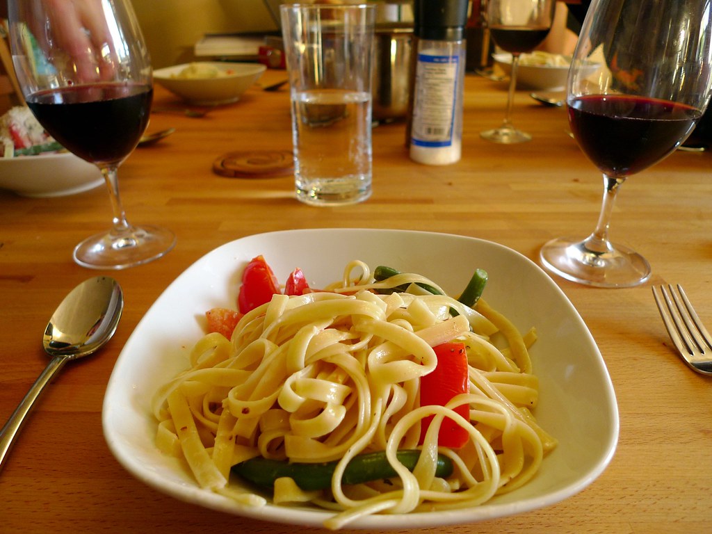Bowl of fettuccine pasta with vegetables on a dinner table