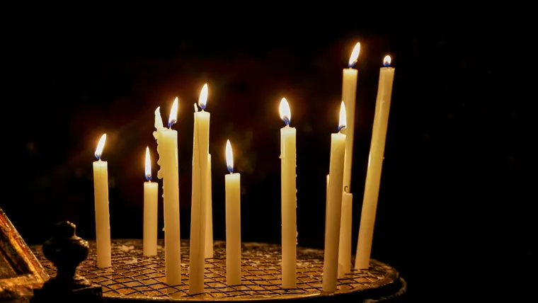 Velas votivas acesas em uma igreja com pouca luz