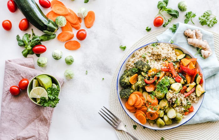 Bowl of rice and vegetables beside fresh produce on a light surface for dinner ideas with few ingredients