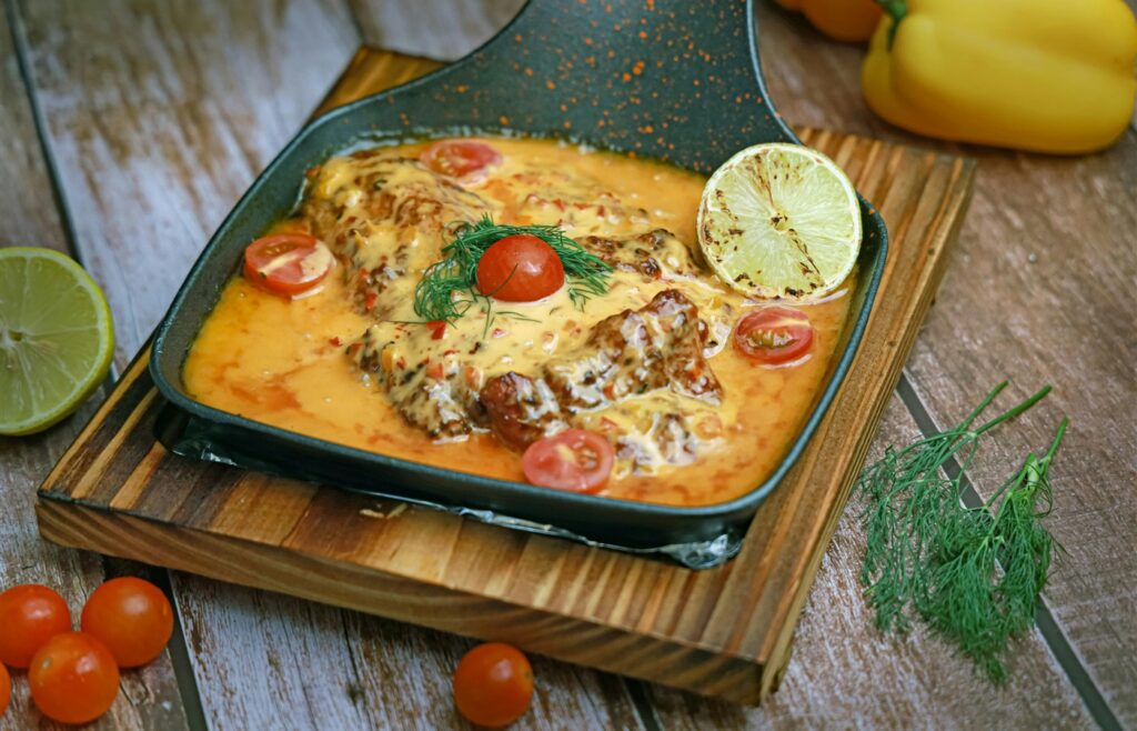 Skillet meal with fish fillets, creamy sauce, tomatoes, and herbs for one-pan dinner ideas for beginners