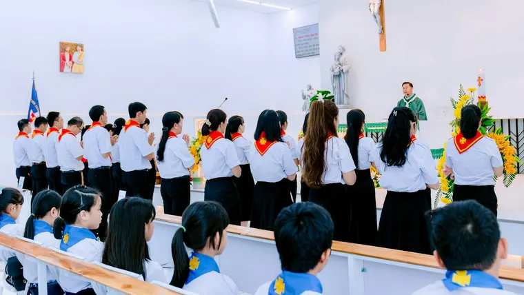 Jovens reunidos em culto na igreja, ouvindo o padre.