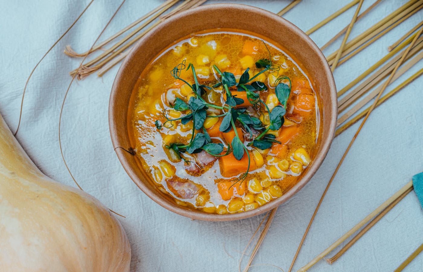 Corn and carrot soup in a brown bowl