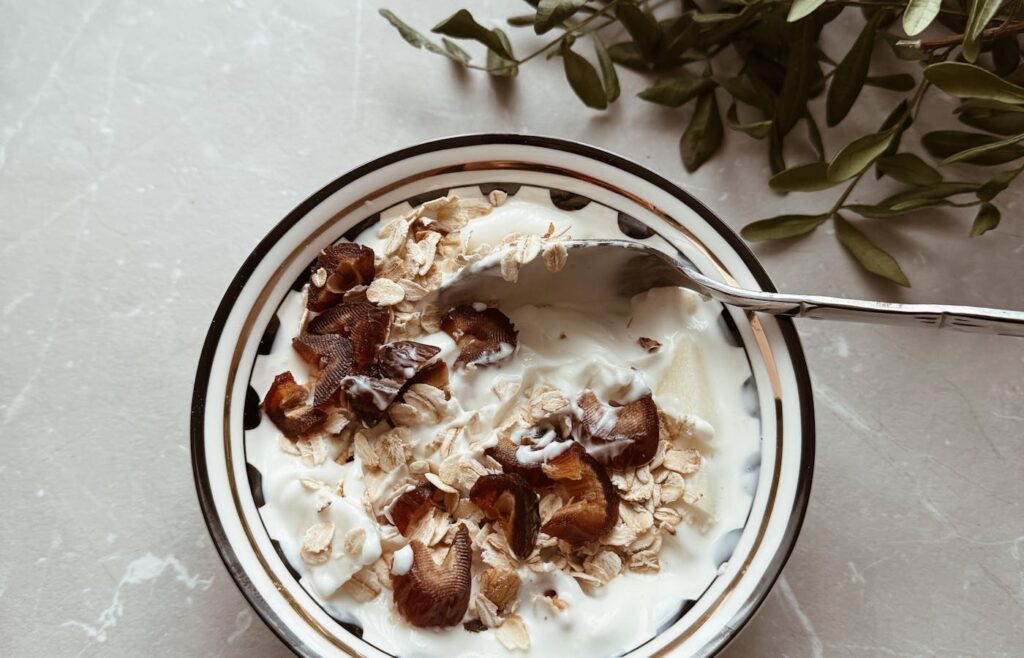 Breakfast yogurt bowl with oats dates and a spoon