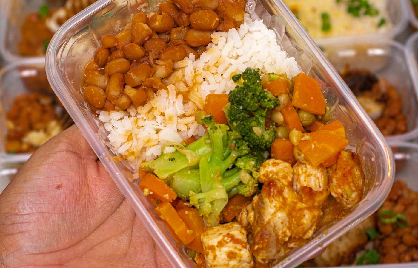 Meal prep container with rice vegetables beans and chicken