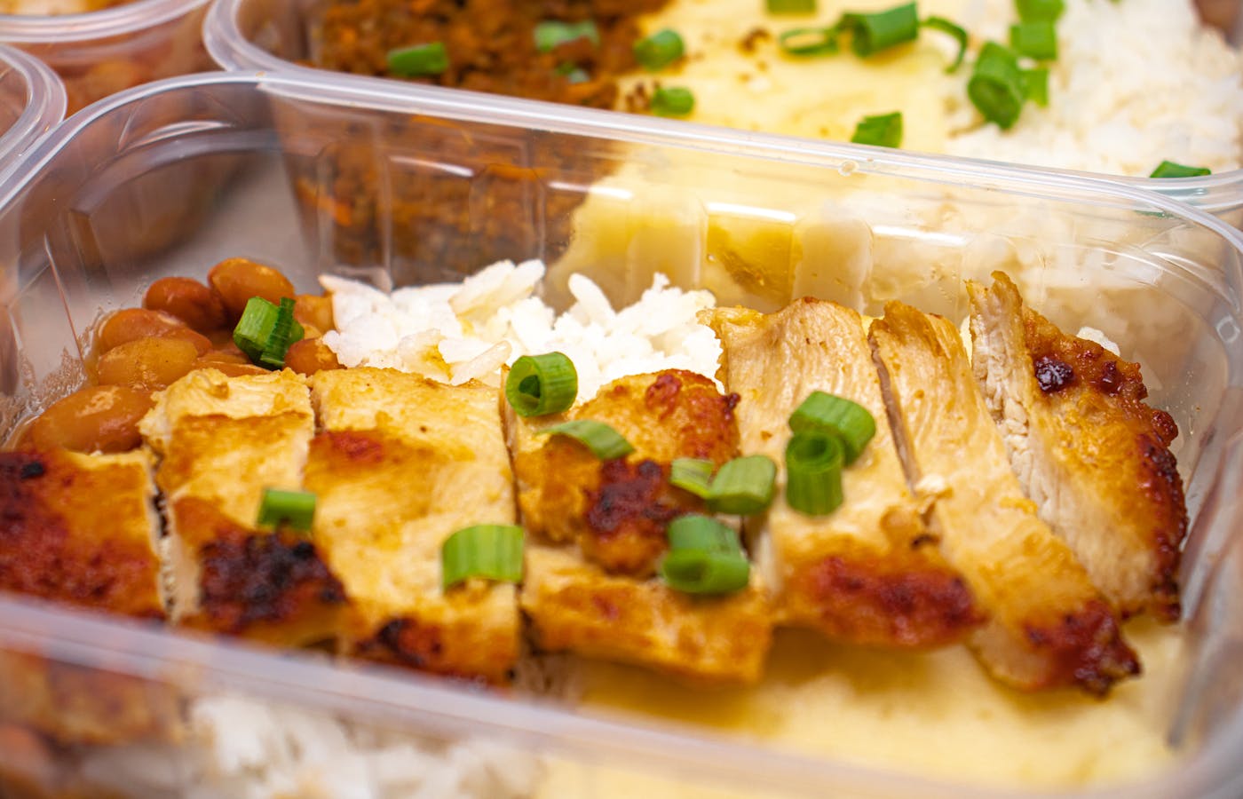 Chicken and rice meal prep container with green onion