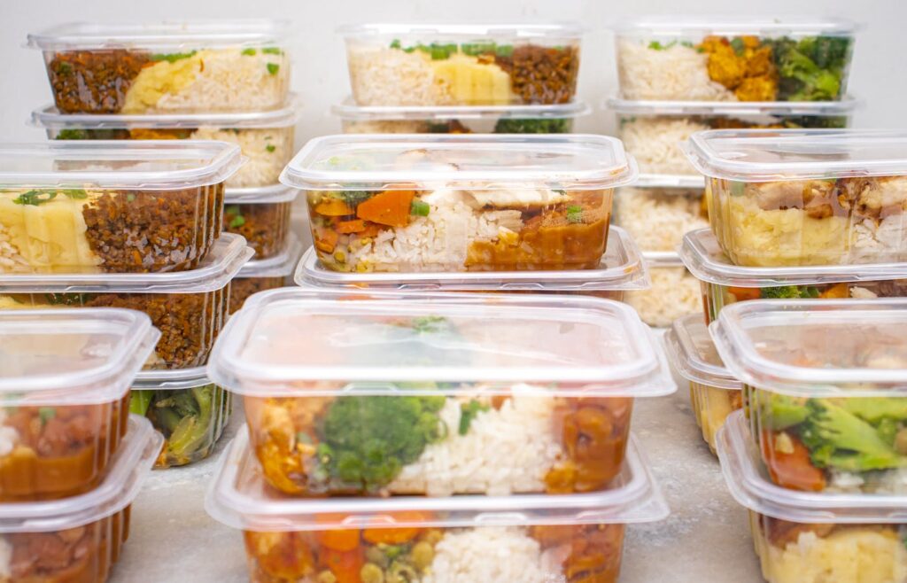 Stacked meal prep containers with rice chicken and vegetables