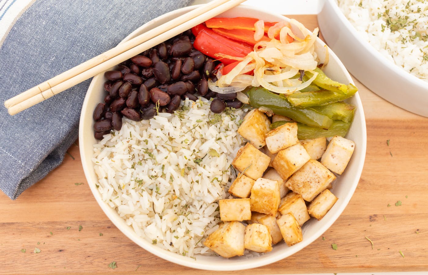 Cheap healthy rice bowl with black beans tofu peppers and onions