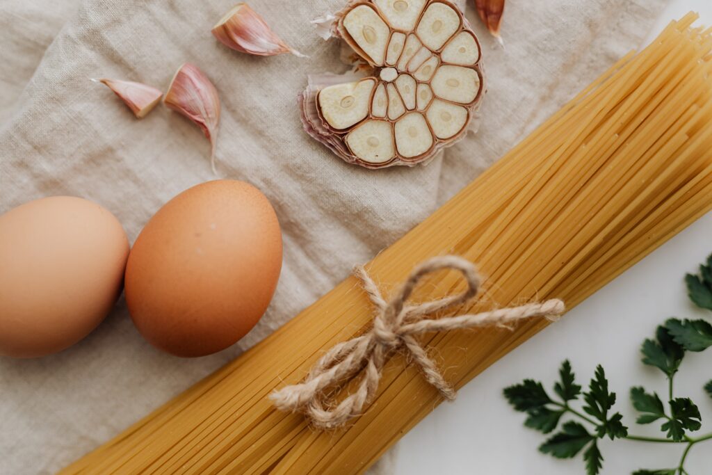 Dry spaghetti eggs garlic and parsley on a cloth