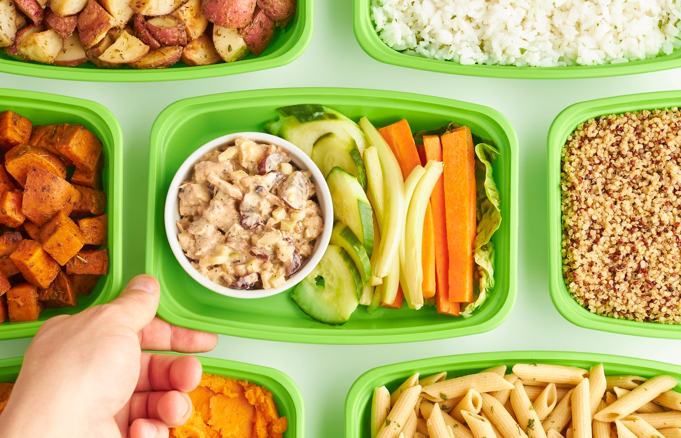 Meal prep containers filled with rice, vegetables, pasta, and roasted potatoes