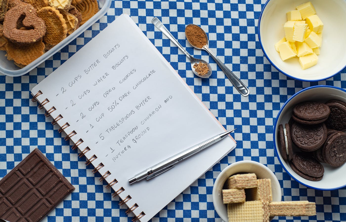 Recipe notebook with cookie ingredients on blue checkered cloth
