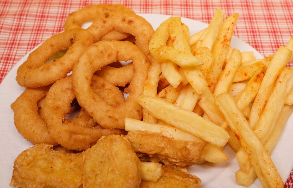 Air fryer basket with cooked golden food pieces