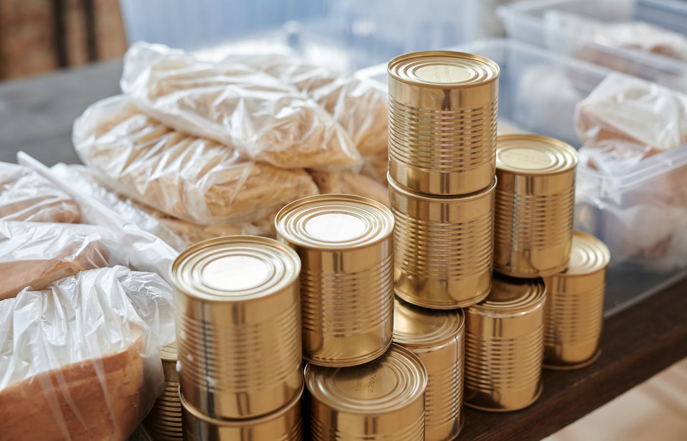 Stacked canned food beside bags of pantry staples