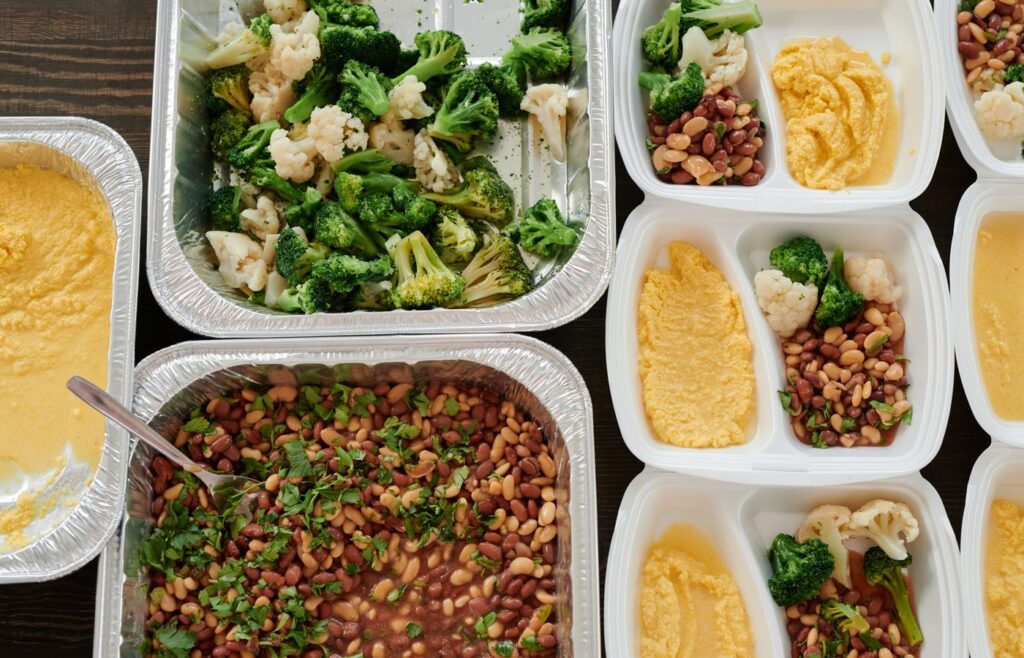 Meal prep containers with beans broccoli cauliflower and polenta