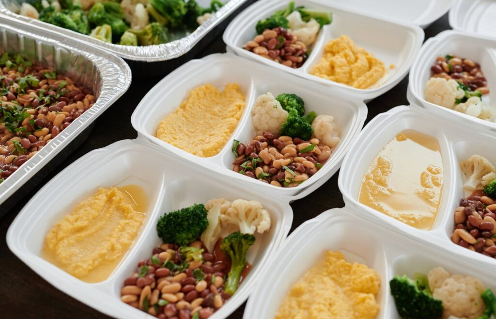 Prepared meal containers with beans, vegetables, and hummus
