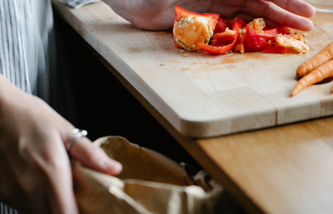 Pepper scraps and carrots on kitchen cutting board