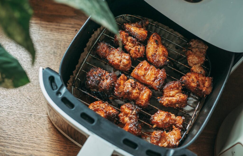 Chicken pieces cooking in an air fryer basket