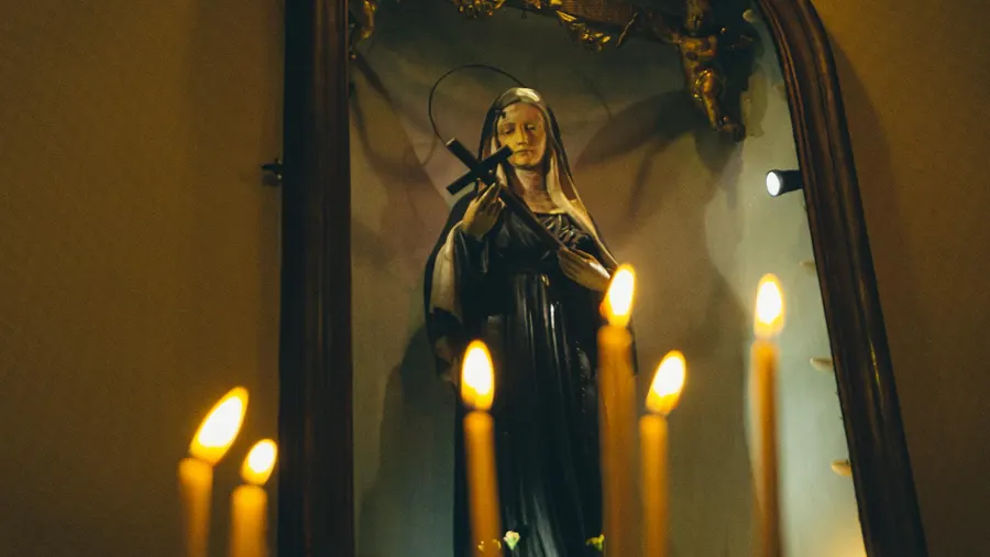 Estátua de santo sagrado em ambiente religioso, com clima de devoção.