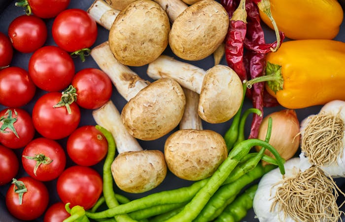 Fresh vegetables for quick pasta, including tomatoes, mushrooms, peppers, onions, and garlic