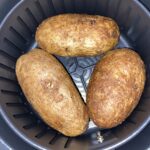 Baked potatoes cooked inside an air fryer basket
