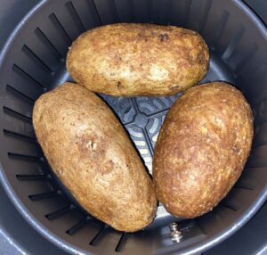 Baked potatoes cooked inside an air fryer basket