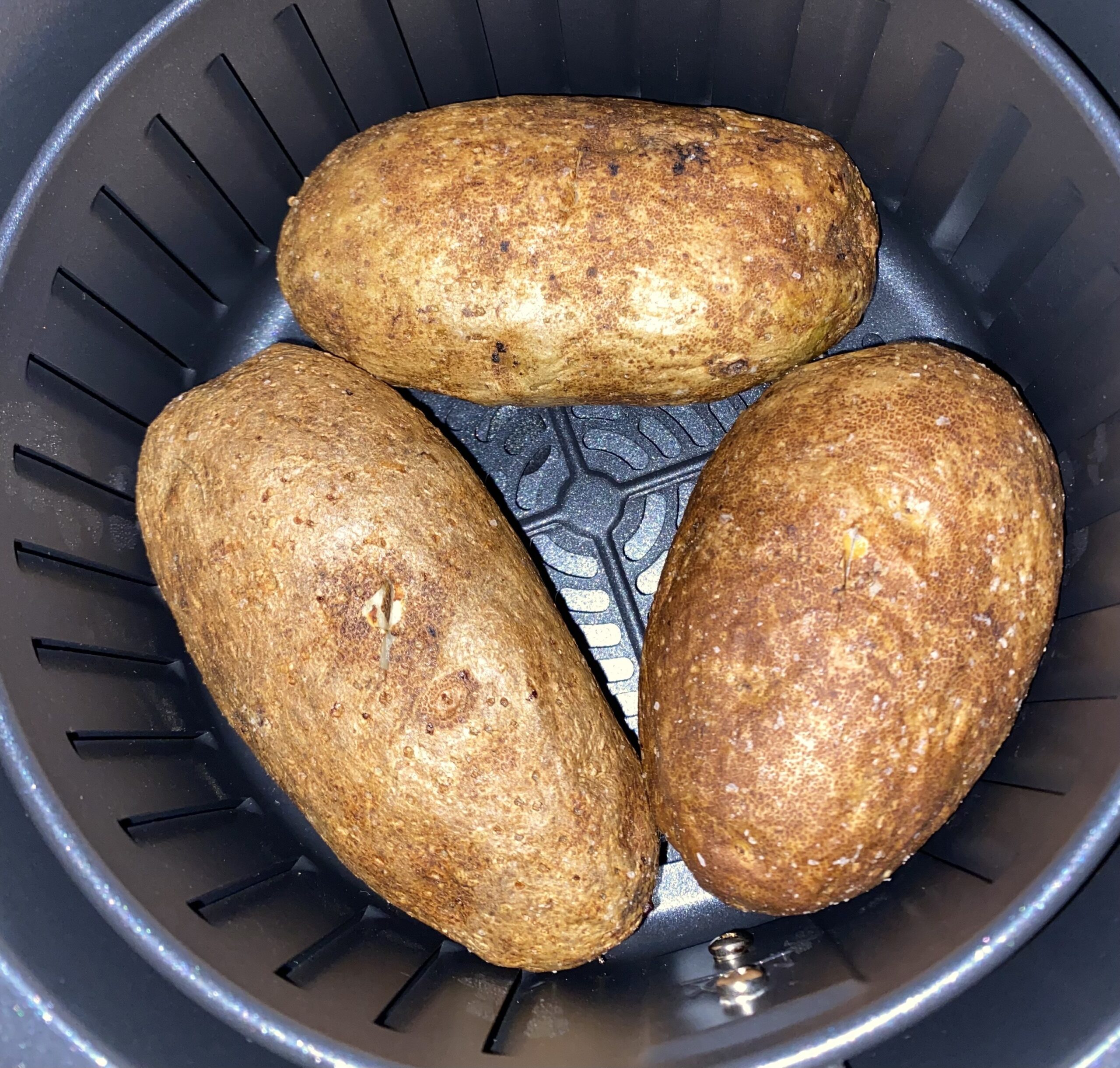 Baked potatoes cooked inside an air fryer basket