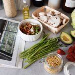 Open cookbook beside fresh ingredients on a kitchen counter