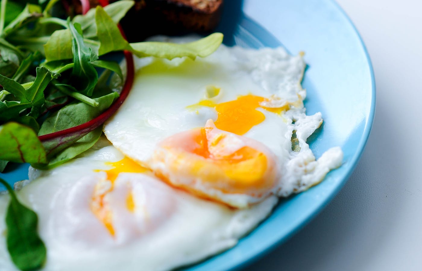 Breakfast plate with fried eggs greens and toast