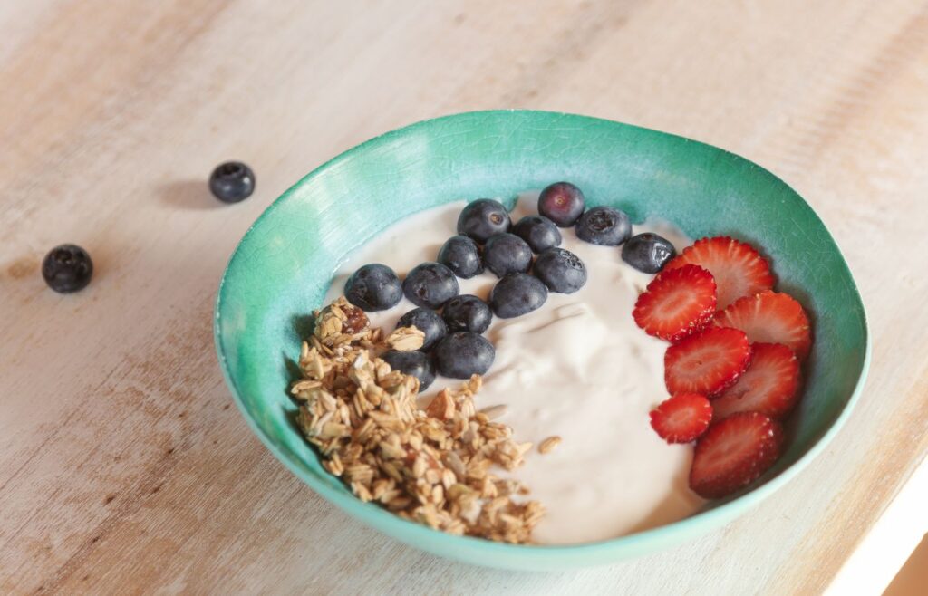 School morning yogurt bowl with granola blueberries and strawberries