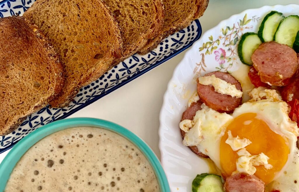 Breakfast table with eggs toast coffee and cucumber slices