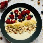 Oatmeal breakfast bowl with berries banana nuts and yogurt