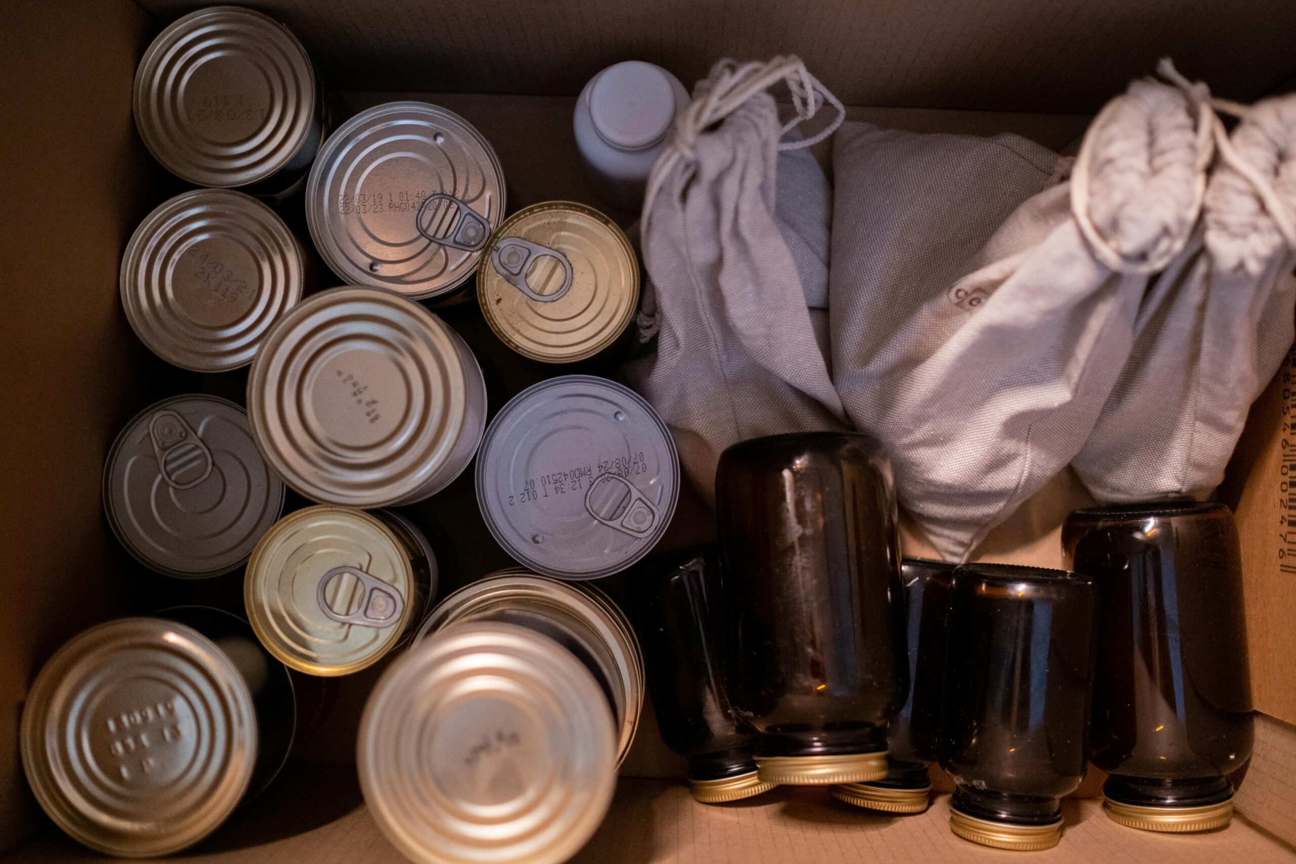 Box filled with canned food jars and pantry supplies