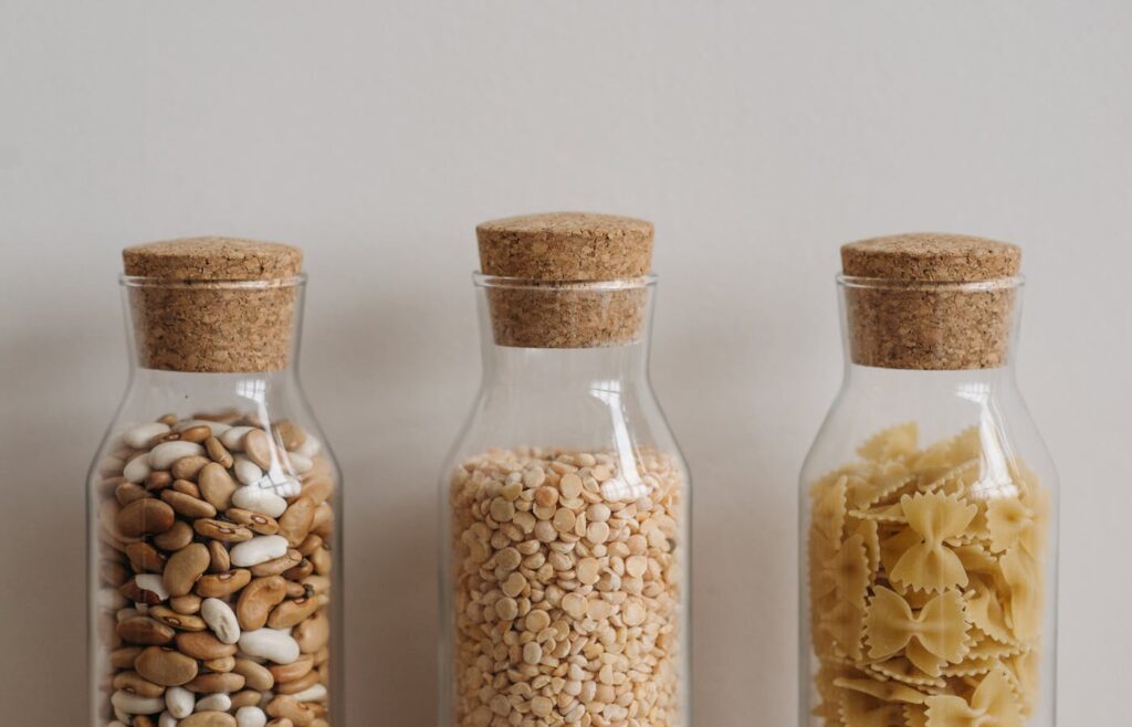 Pantry jars filled with beans lentils and pasta for simple meals